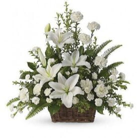 kosz kwiatowy który zawiera białe lilie, białe goździki oraz zielone dodatki, w tym liście paproci