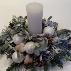 bożonarodzeniowy stroik na stół z gałązek świerku z białymi bombkami choinkowymi i piernikami oraz z białą świecą