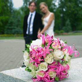 na pierwszym planie jest leżący na marmurze bukiet na ślub cywilny z białych róż i różowych lilii