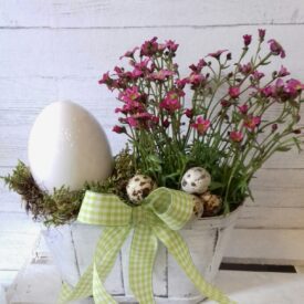 dekoracje na wielkanoc w koszu z fioletowymi kwiatuszkami, jajami