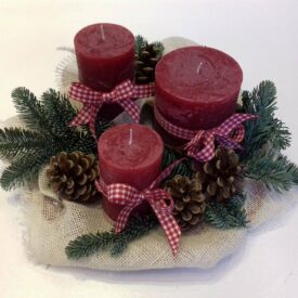 eleganckie stroiki bożonarodzeniowe z trzema bordowymi świecami, gałązkami świerku, z szyszkami i z czerwonymi kokardami