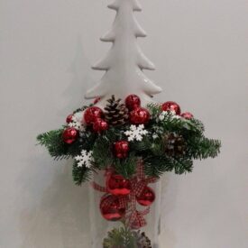 stroik świąteczny w szkle z porcelanową choinką. idealny na stół. ozdobiony gałązkami świerka, czerwonymi bombkami i szyszkami
