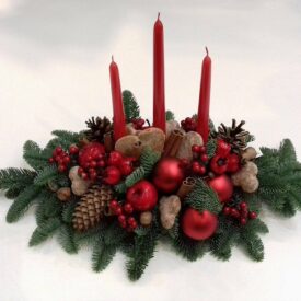 stroiki na stół bożonarodzeniowe z trzema czerwonymi świeczkami, ozdobiony jabłuszkami, czerwoną jarzębiną, z cynamonem i szyszkami