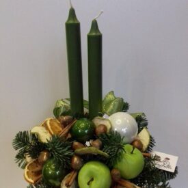 stroiki na stół bożonarodzeniowe zielony z dwiema świeczkami, ozdobiony zielonymi jabłkami, cynamonem i orzechami laskowymi