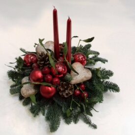 stroiki świąteczne bożonarodzeniowe. ozdoby to jemioła, dwie czerwone świeczki, czerwone bombki choinkowe i serca z piernika