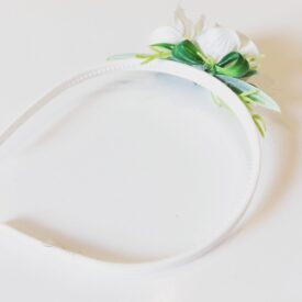 wianek komunijny ze sztucznych kwiatów, w tym przypadku jeden biały kwiatek na froncie wianka
